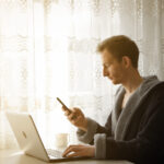 man using laptop and phone