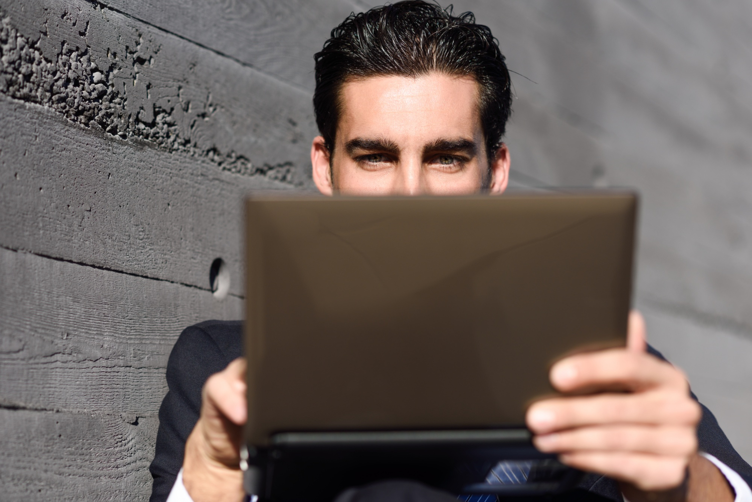 The guy is working on a small laptop